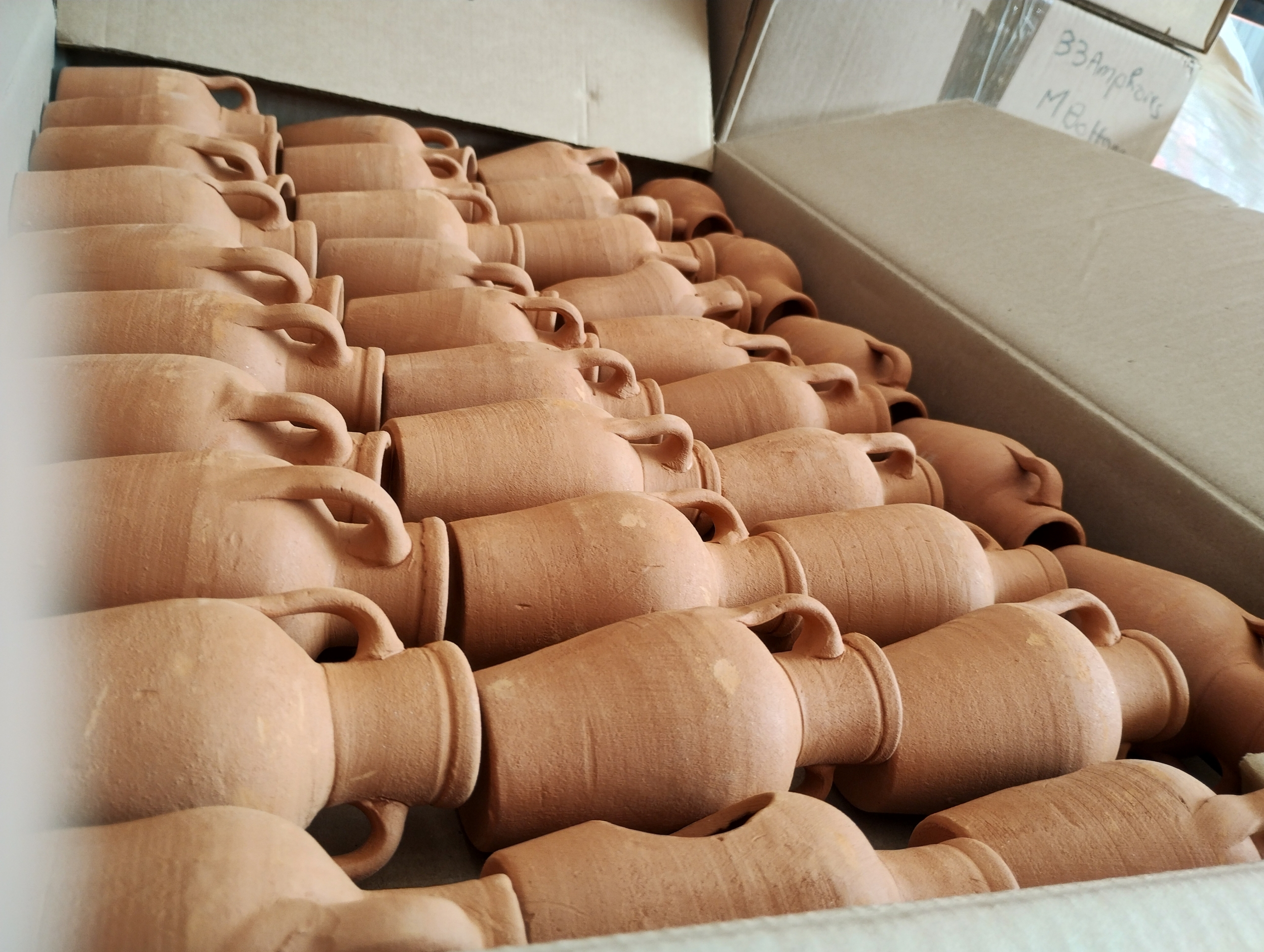 Photo of a box of terracotta amphorae suitable for plants or an aquarium